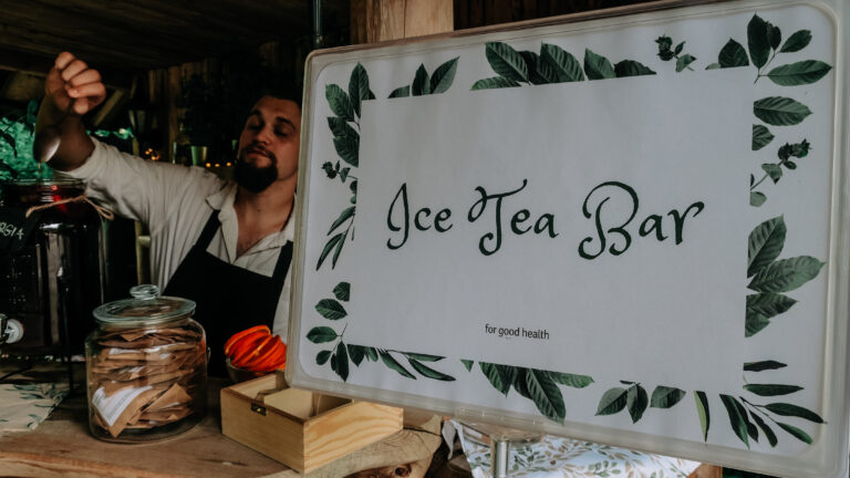 Stand z napisem Ice Tea Bar i barista przygotowujący napój.