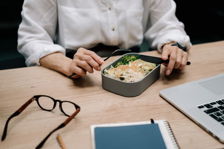 Adult enjoying a&nbsp;healthy meal at the office desk during lunch break.